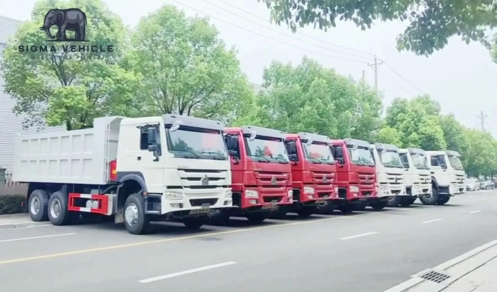 Row of HOWO trucks parked along the roadside before shipment