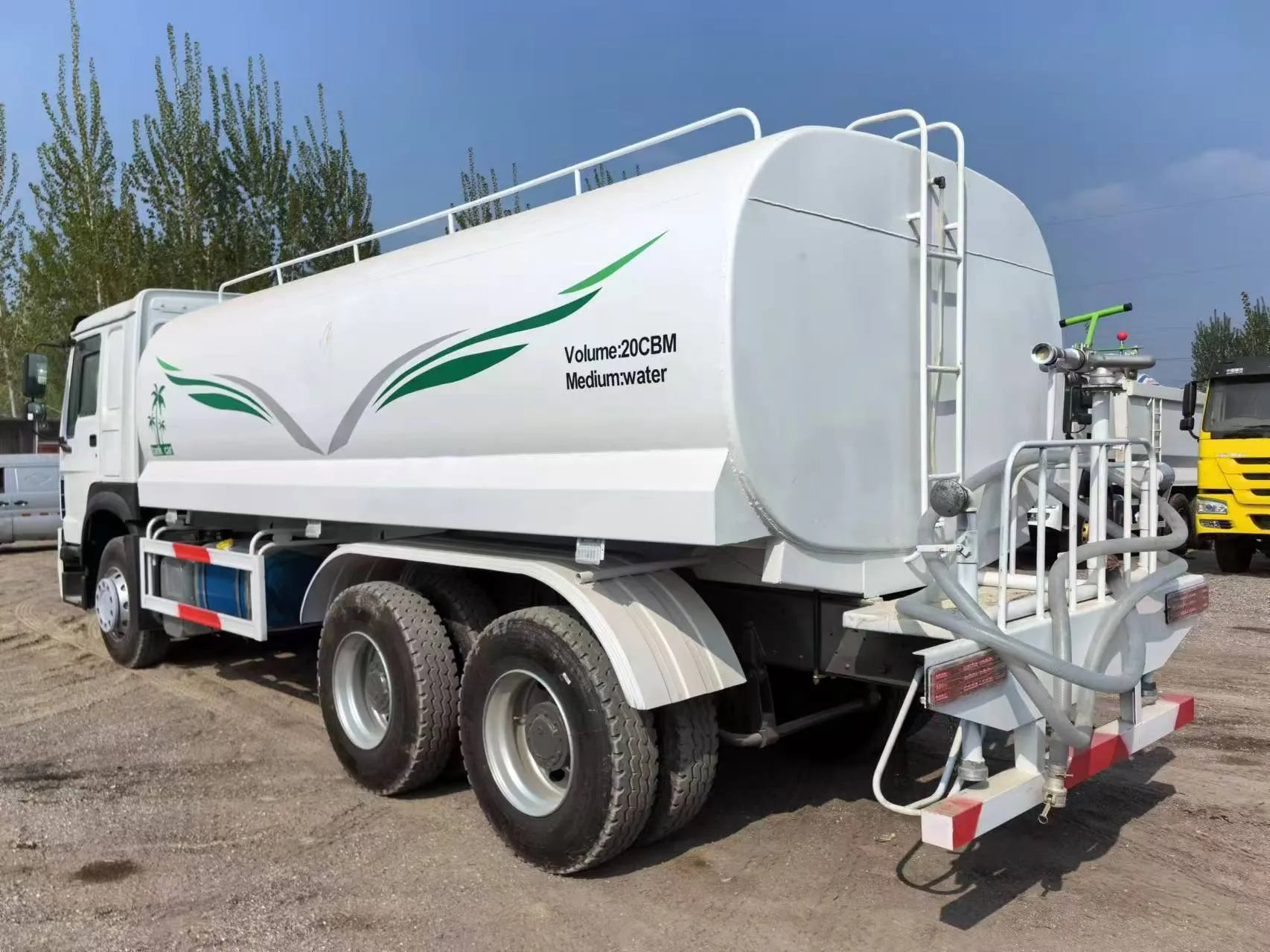 Rear of a 20 m³ water tank truck showing the spray nozzle, hoses and discharge valve assembly