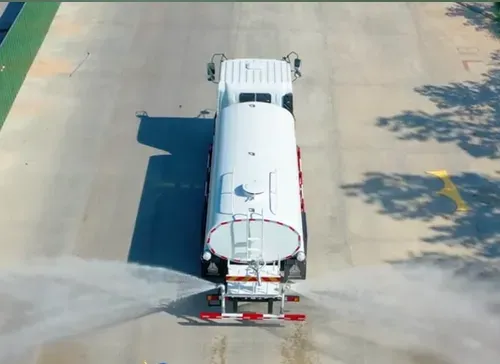 Aerial view of a water tank truck spraying the road surface for dust suppression