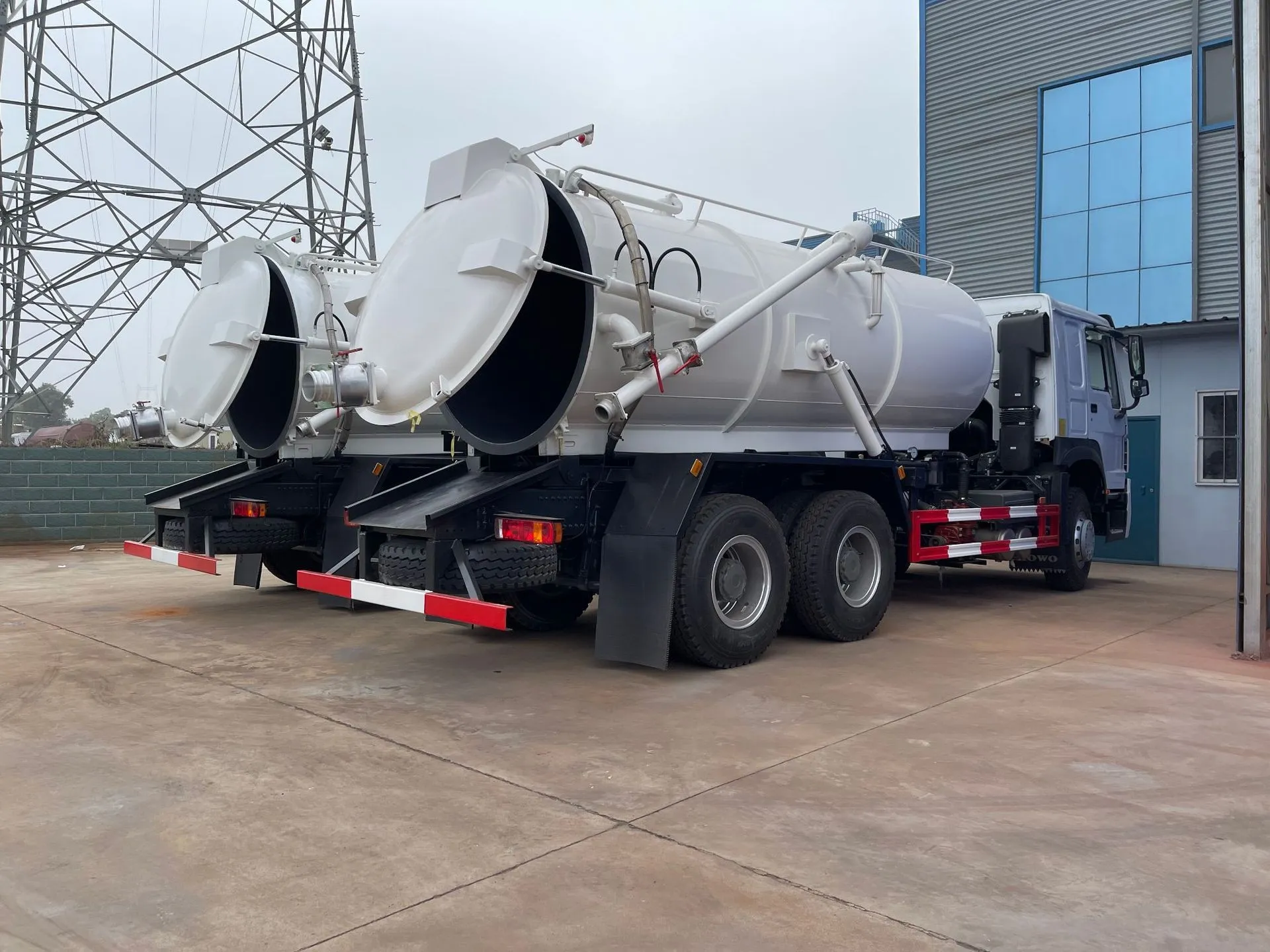 Two 6×4 vacuum tankers parked side by side with rear doors open before final inspection